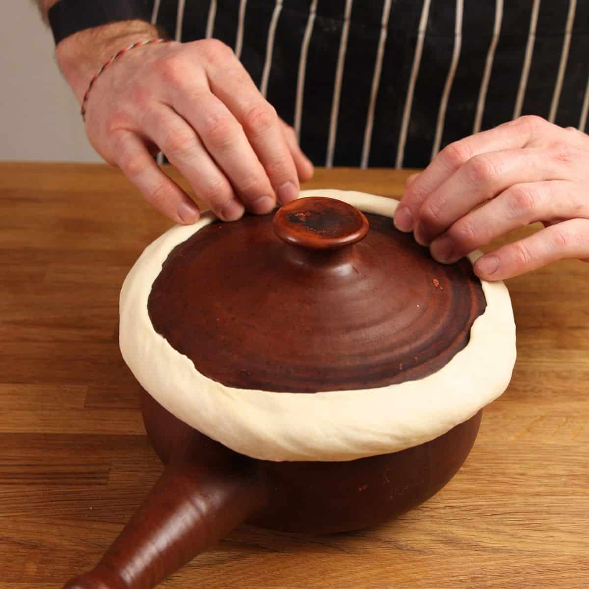 Sealing dough and lid of clay pot.