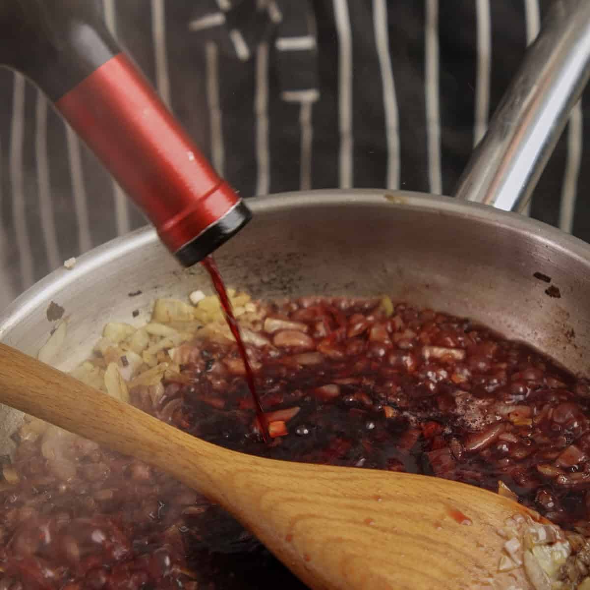 Adding red wine to caramelized onions.