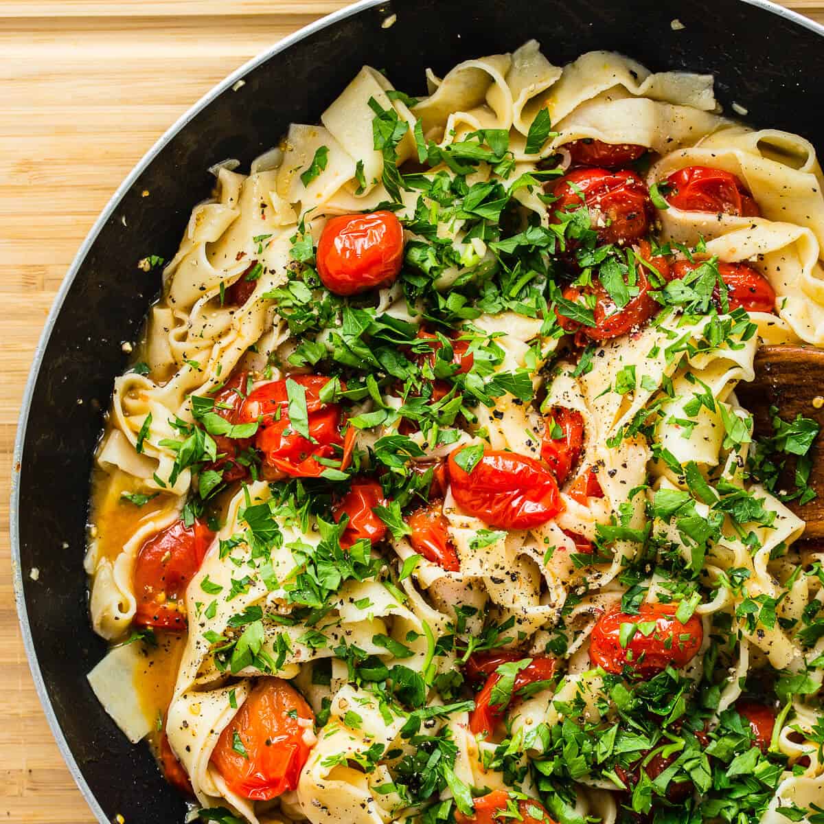 Pasta added to cooked tomatoes with freshly chopped parsley.
