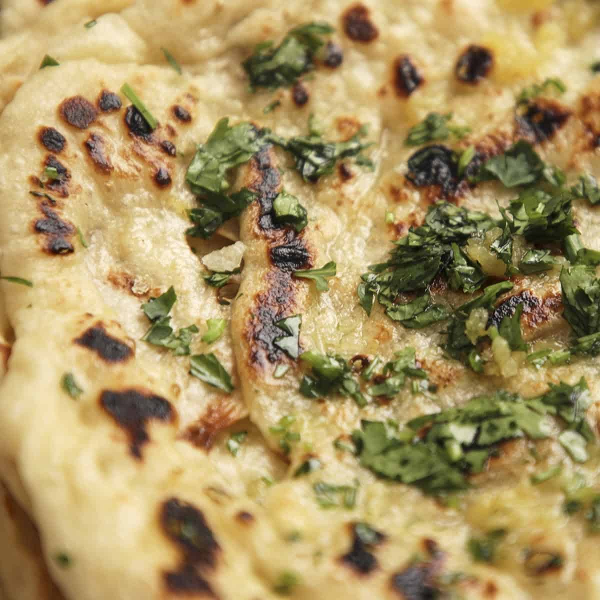 Adding chopped cilantro and flakey salt to garlic butter naan.