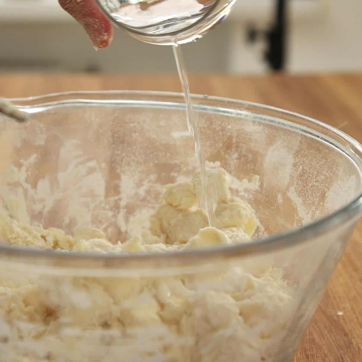 Adding cold water to butter and flour mix