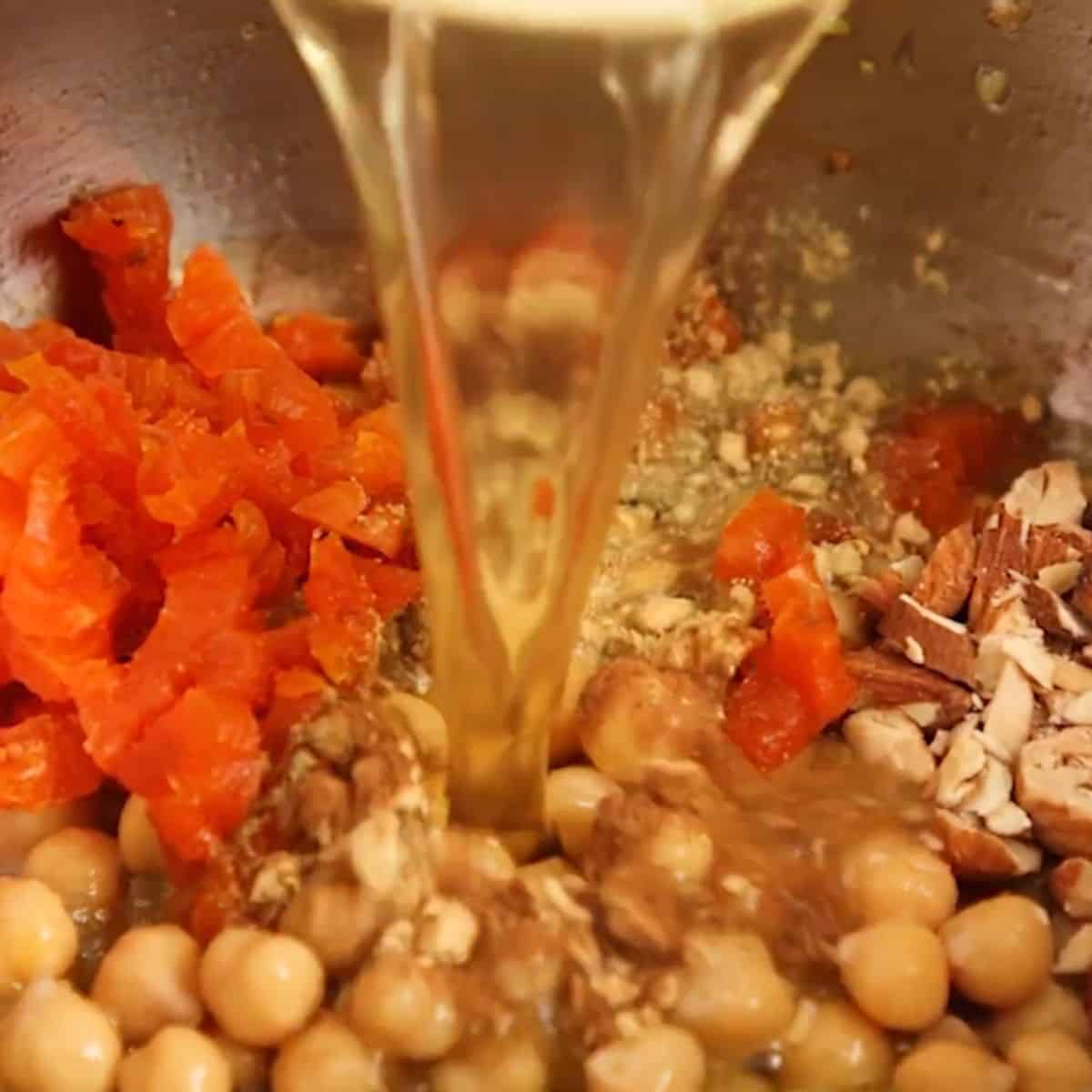 Adding stock and spiced to aromatics.