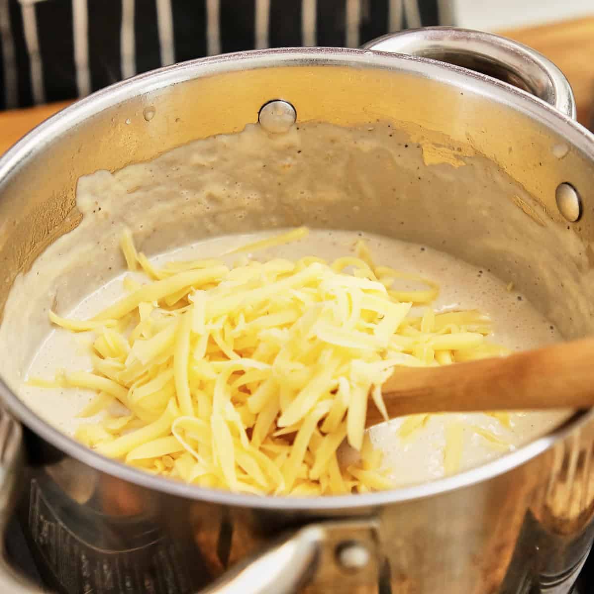 Grated cheddar added to the biltong soup base off the heat.