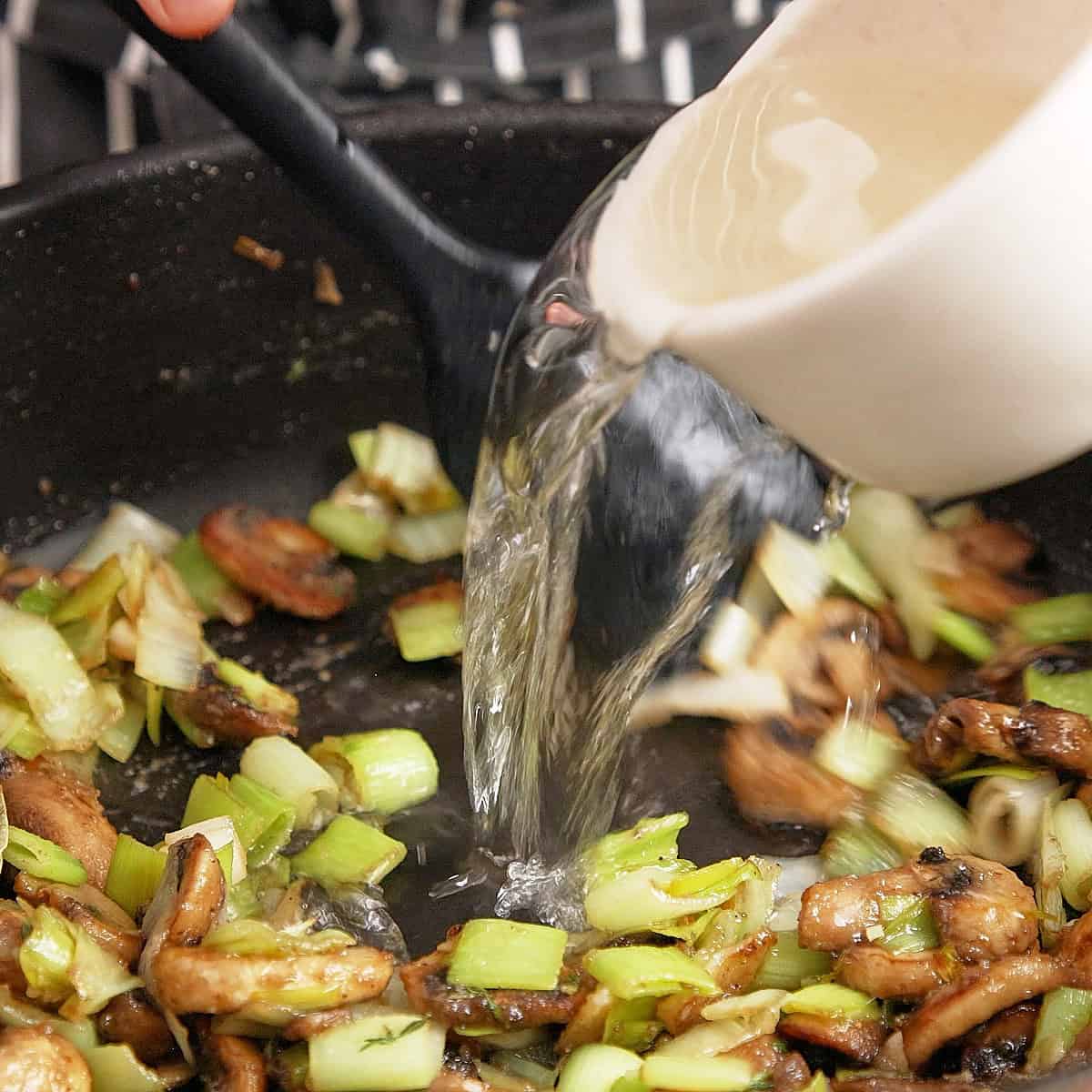 Adding wine to a pan to reduce.