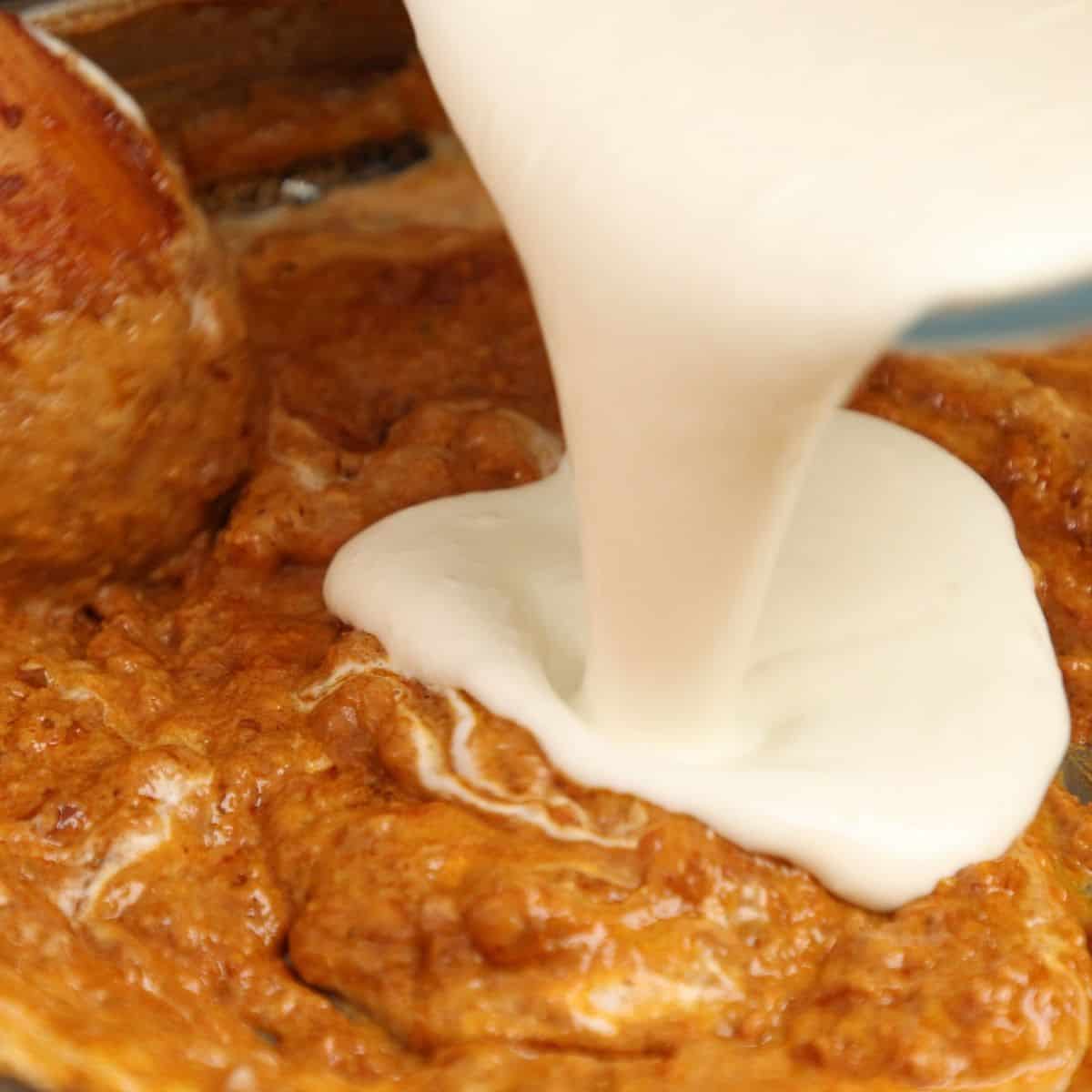 Adding whipped yogurt to make the gravy.