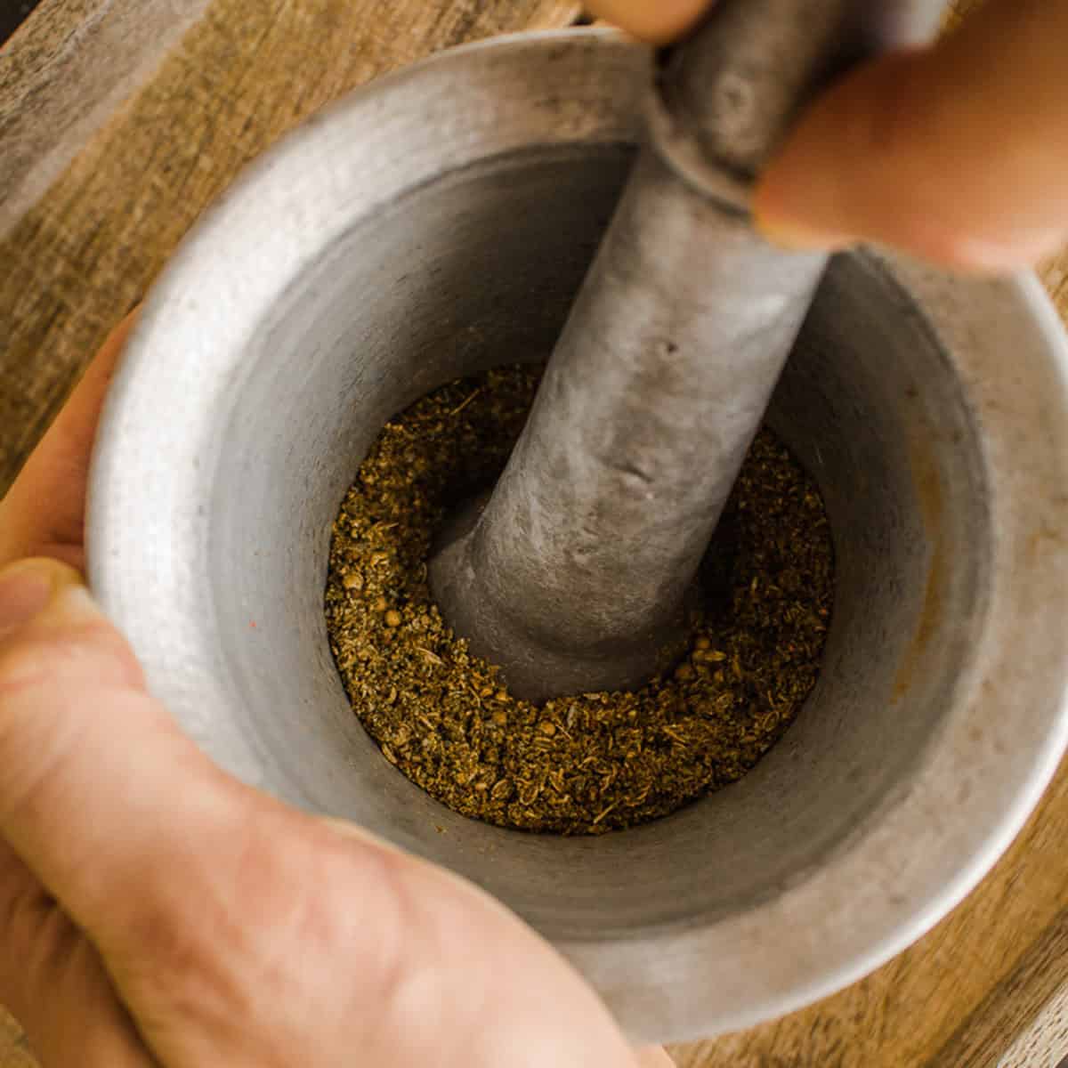 Grinding spices in pestle and mortar.