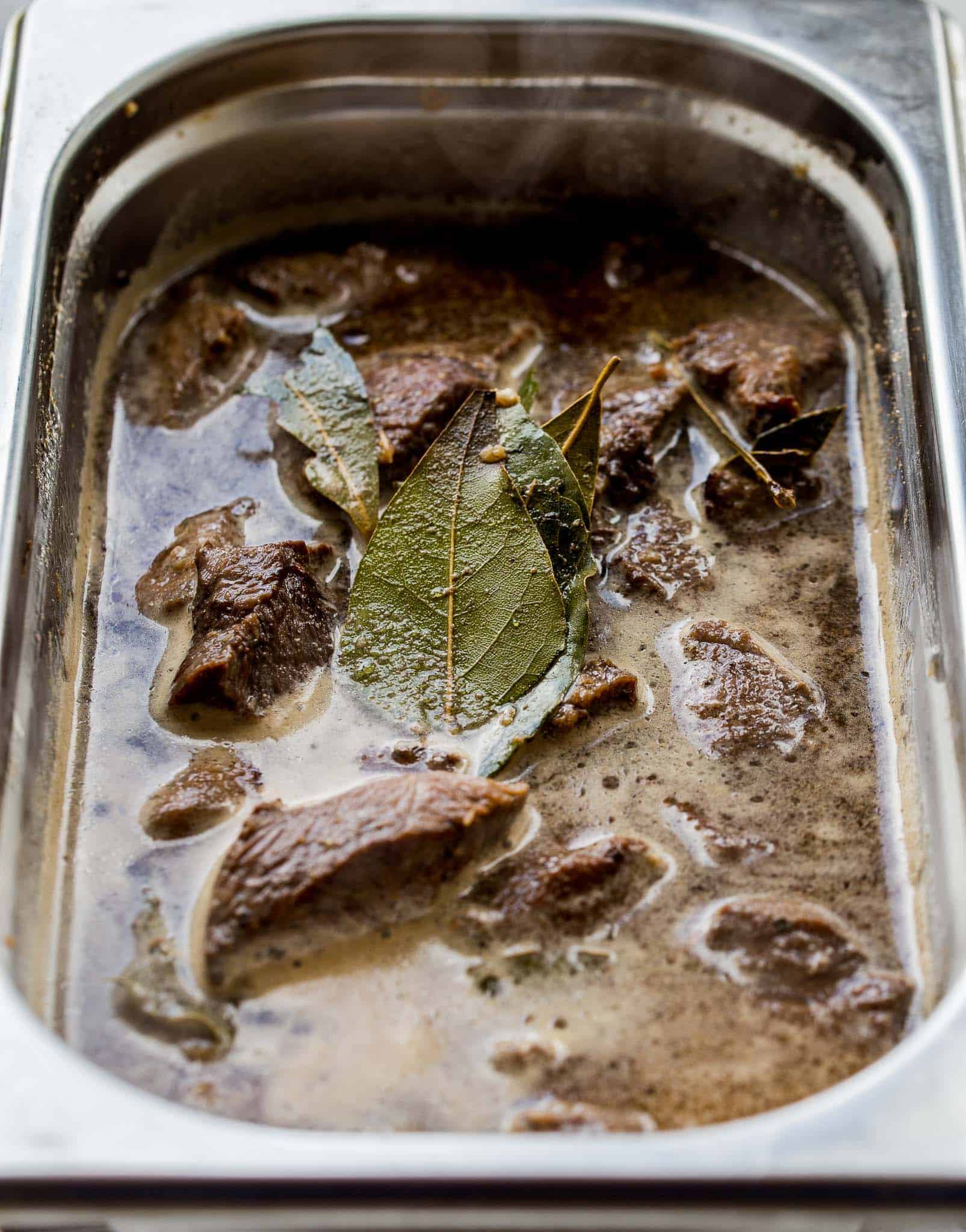 Beef ready to braise in container.