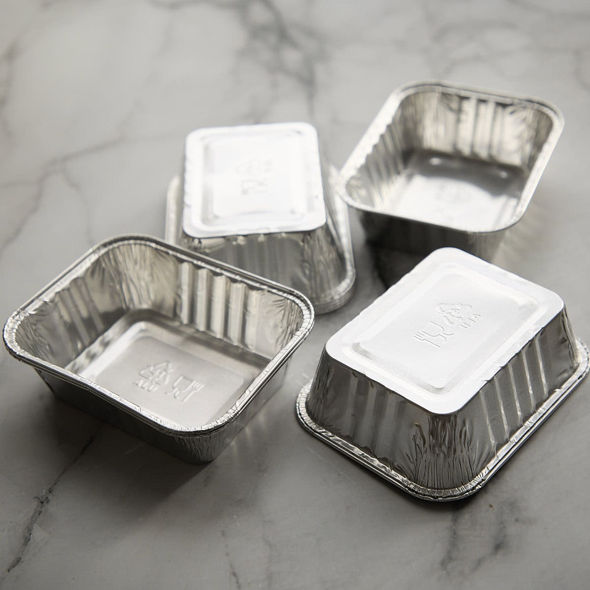 Aluminum pie tins on a marbled surface.