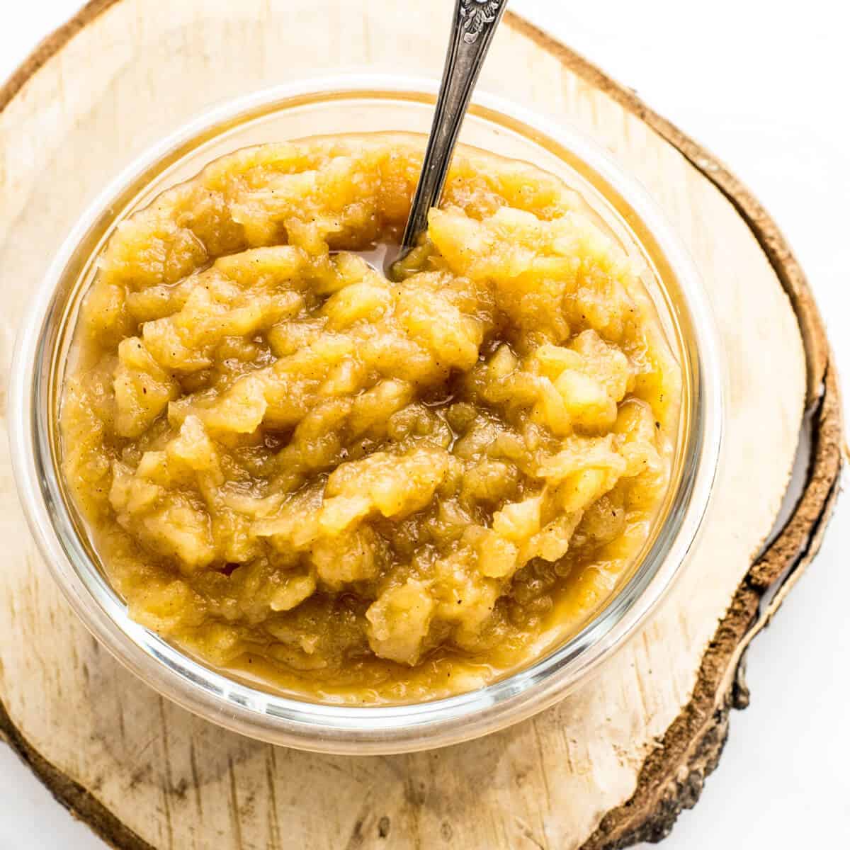 apple sauce in a glass jar on a wooden board 