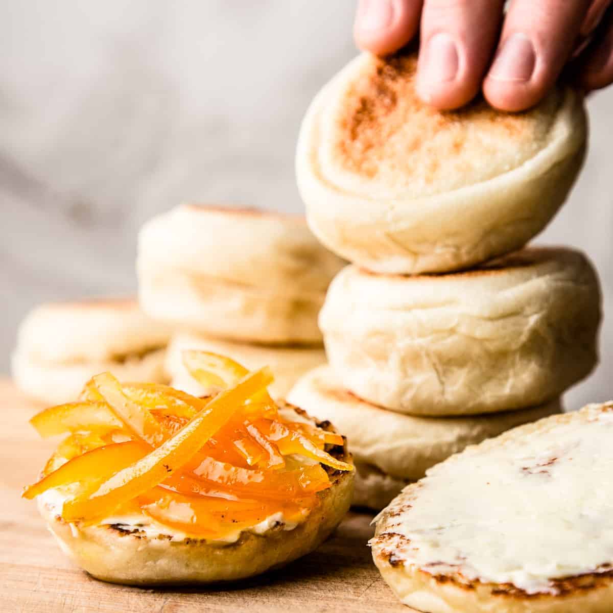 English muffins with orange marmalade on wooden board.