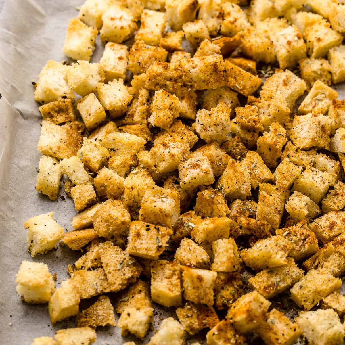 Baked brioche bread croutons on a tray.
