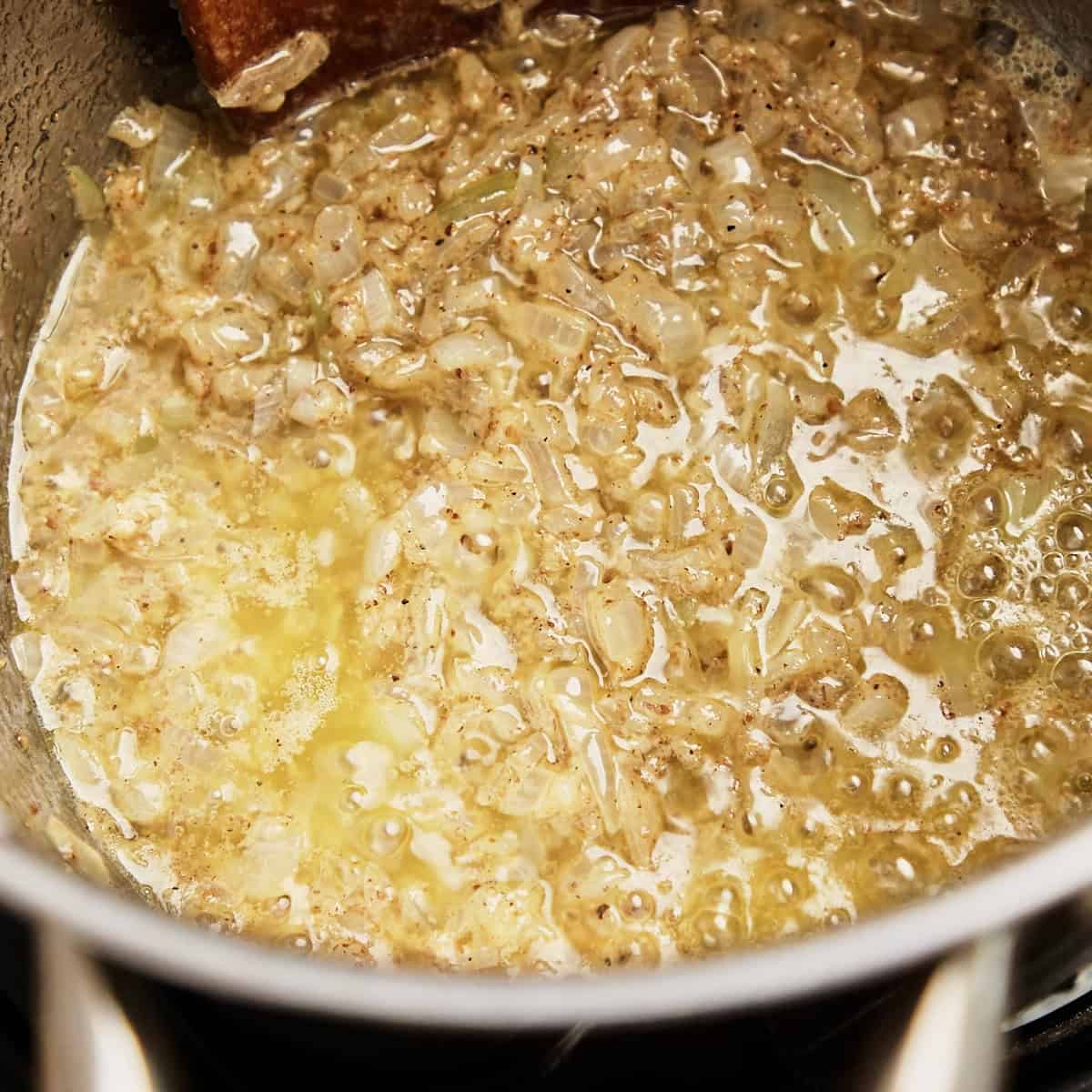 Butter, Dijon mustard, and ground spices stirred into softened onions for biltong soup.