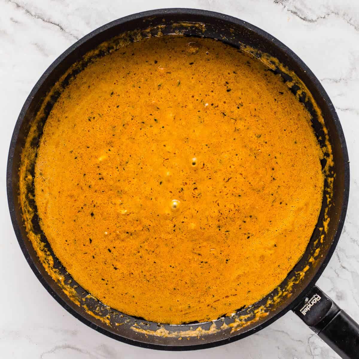 Butter chicken sauce simmering and smooth.
