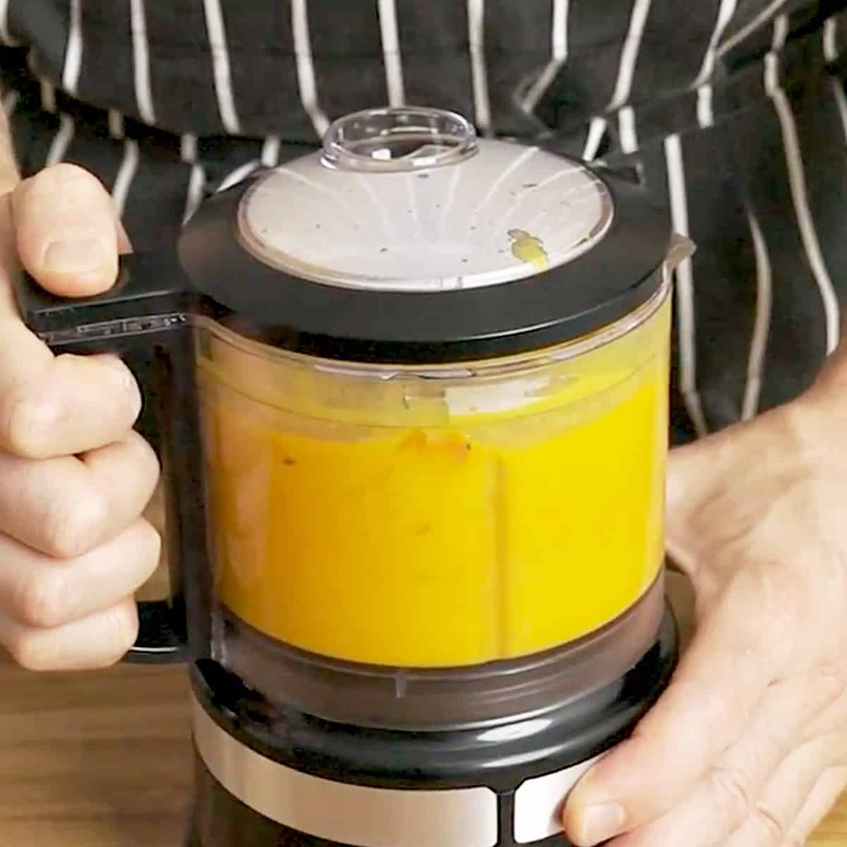 Blending pumpkin soup in a blender.