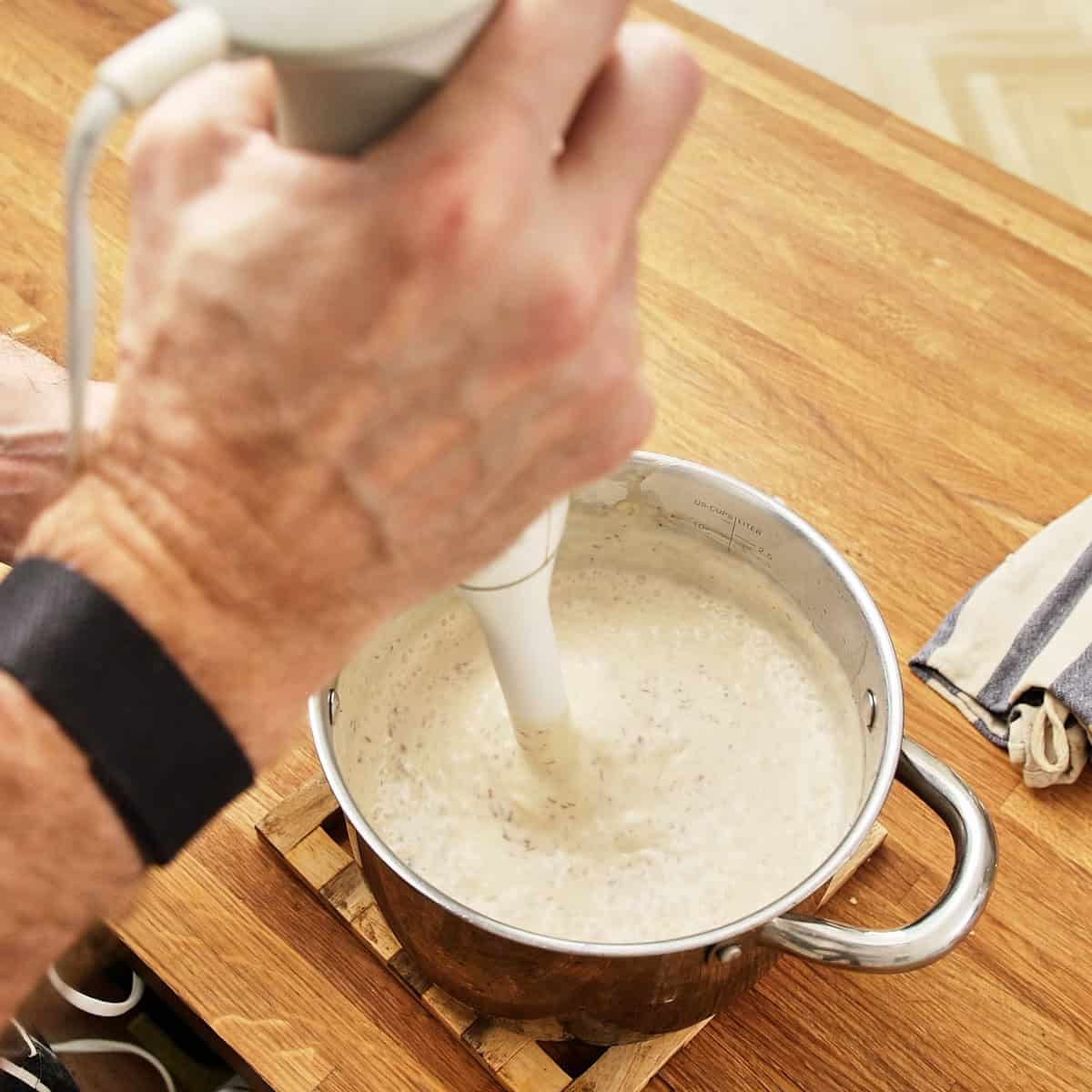 Blending soup with hand blender.