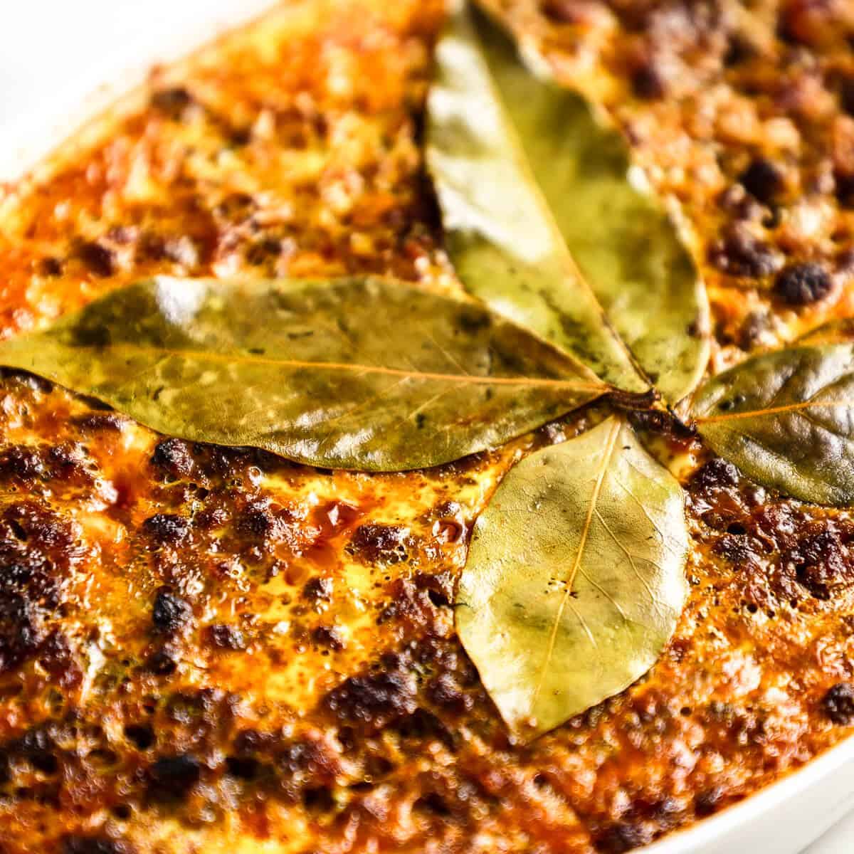 Close up of bobotie in a white ceramic dish.