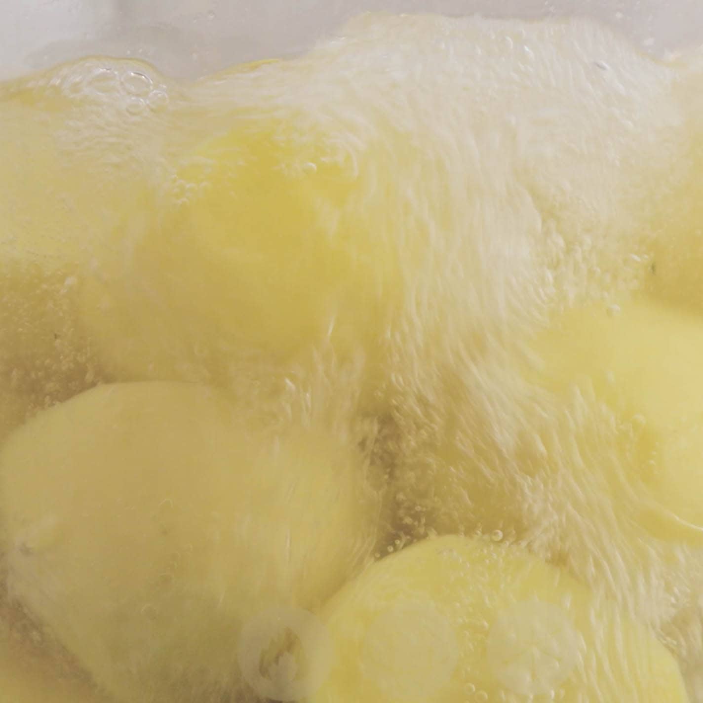 Potatoes boiling in a pot.