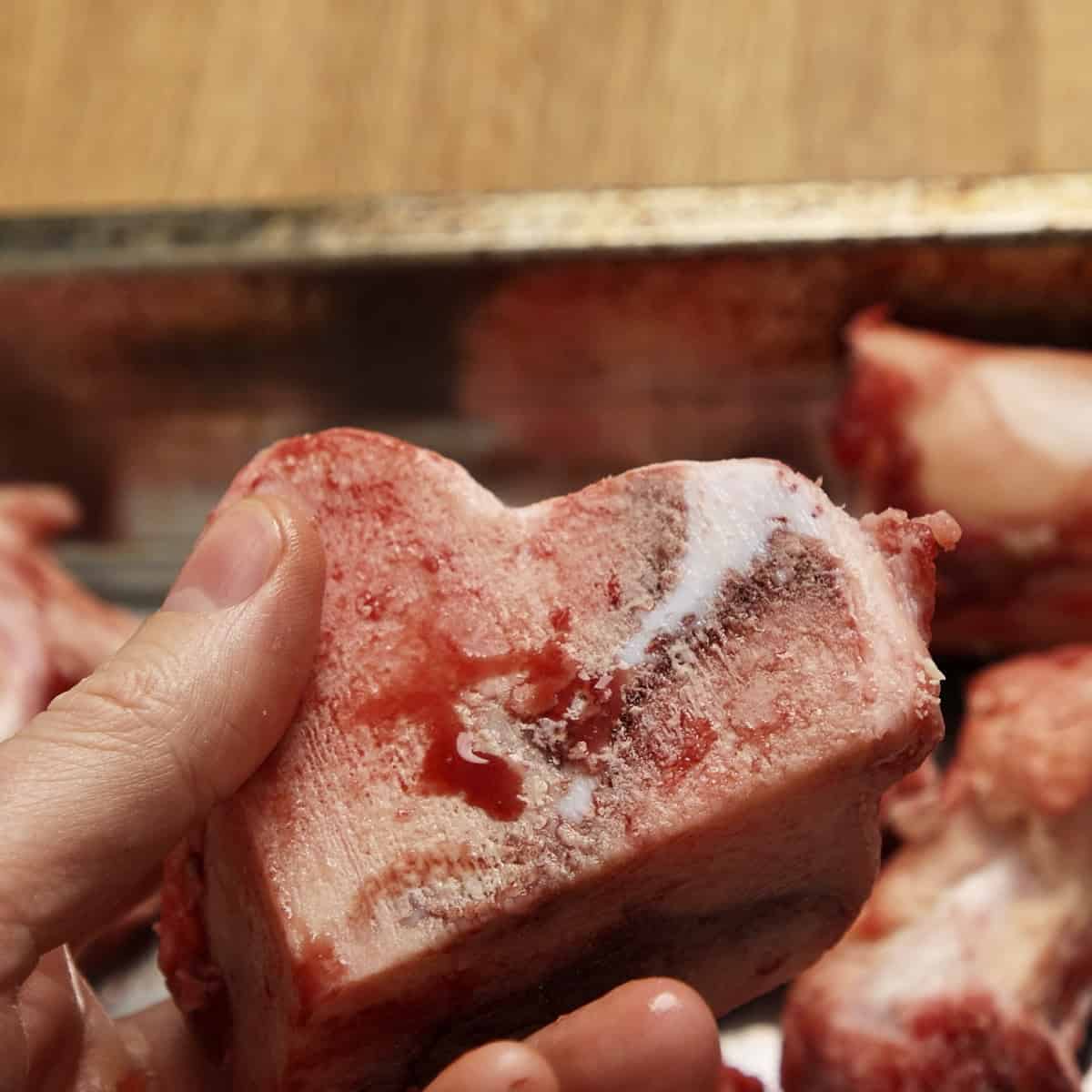 Beef marrow bones for beef stock in hand.