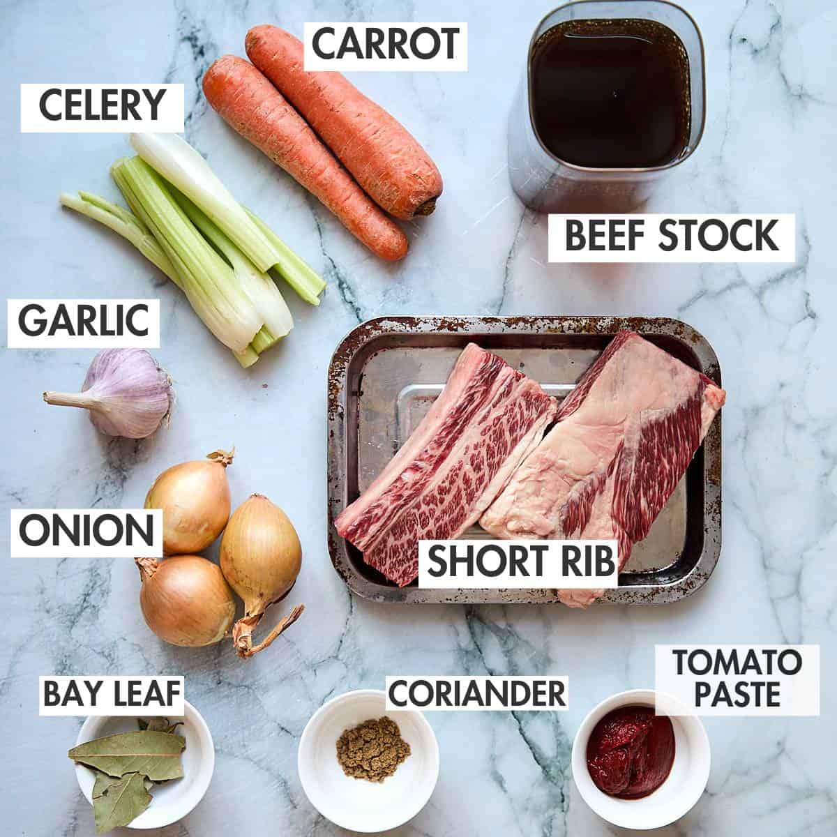 Base ingredients for braised short rib on a marbled surface.