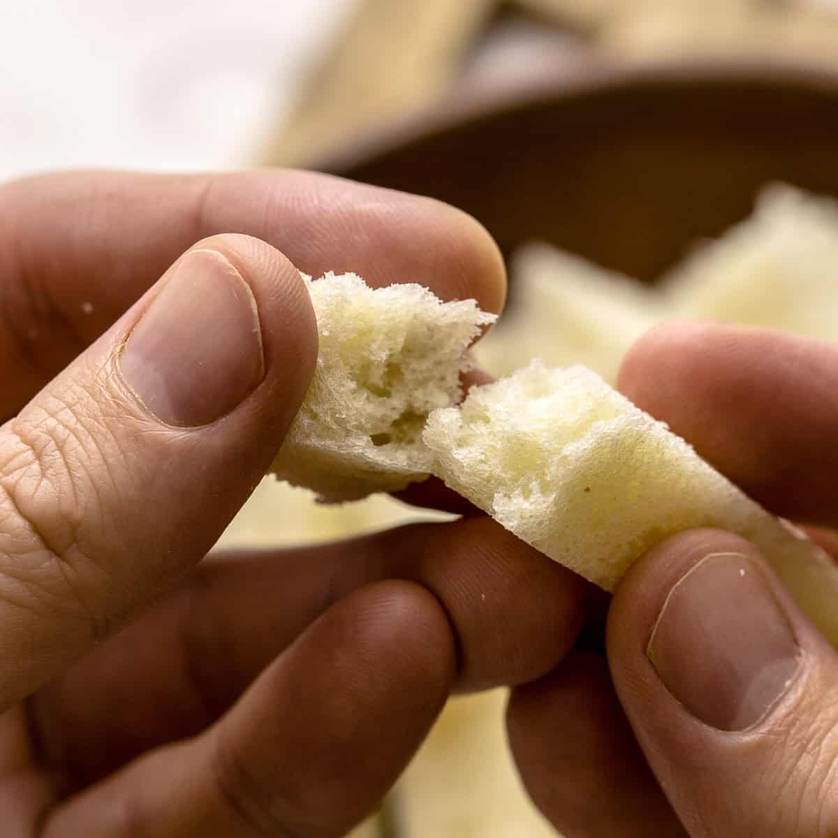 Breaking brioche bread with two hands.