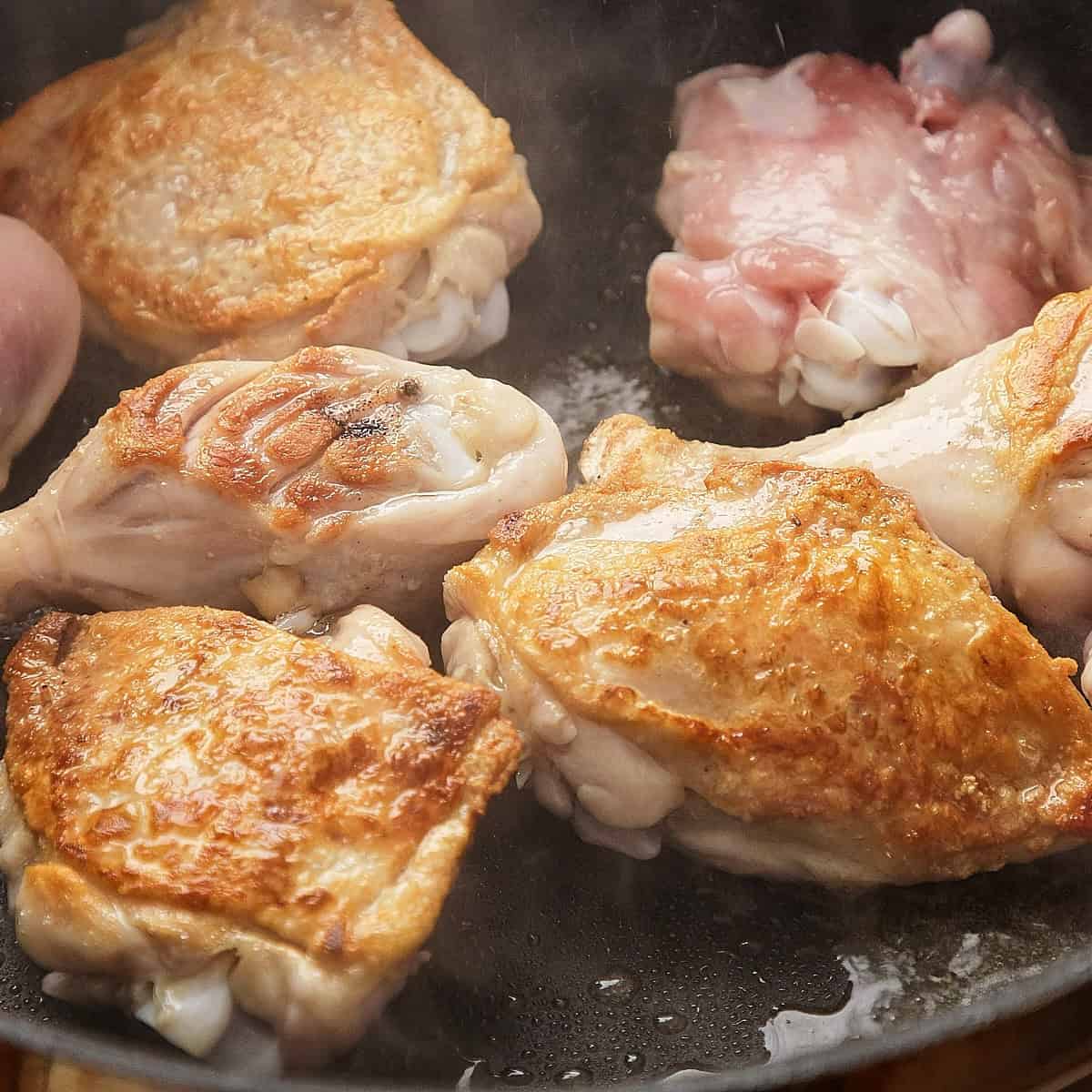 Browning chicken in a pan.