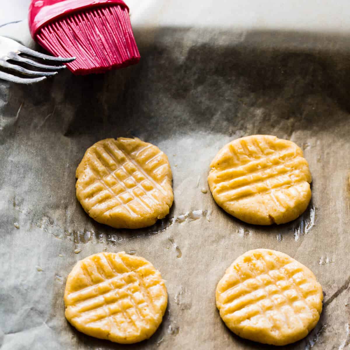 Brushing Parmesan shortbread with egg wash.