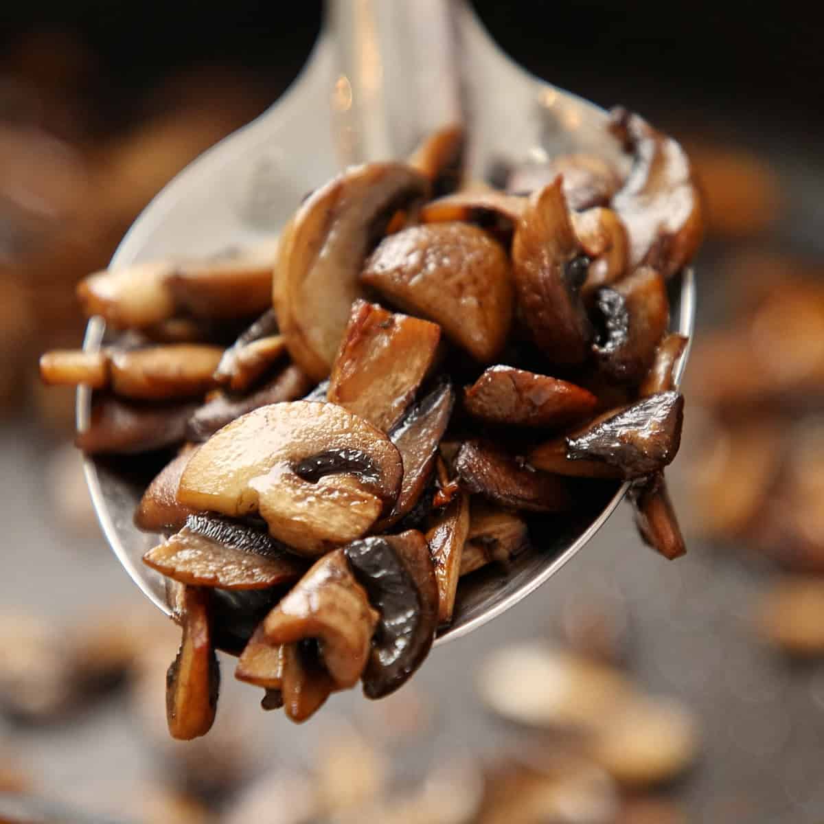Deeply caramelized mushrooms glistening on a spoon.
