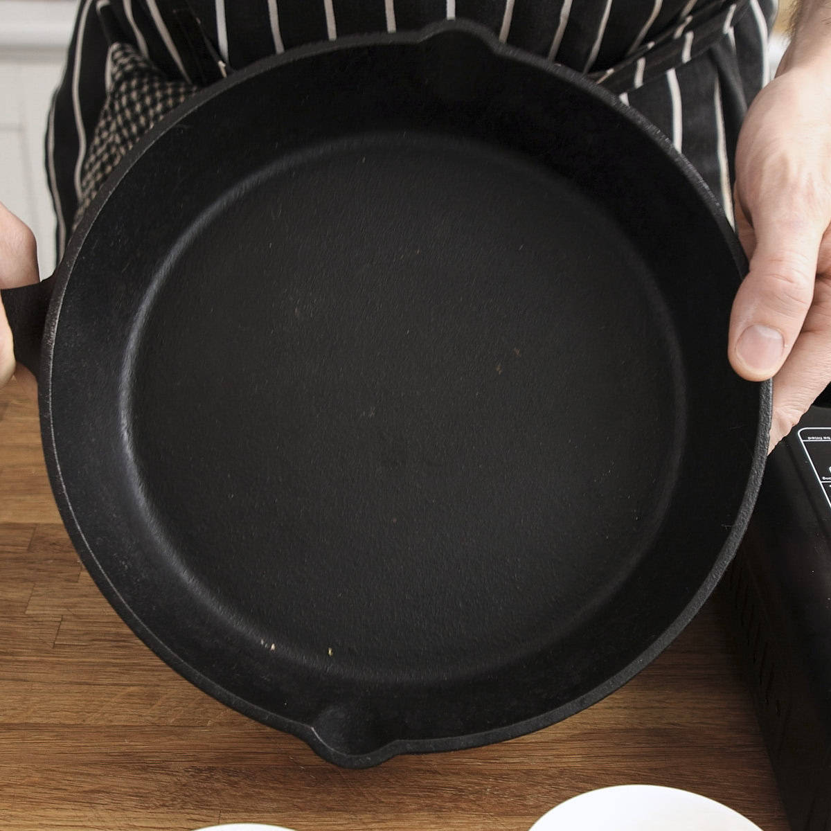 Black skillet held in hands.