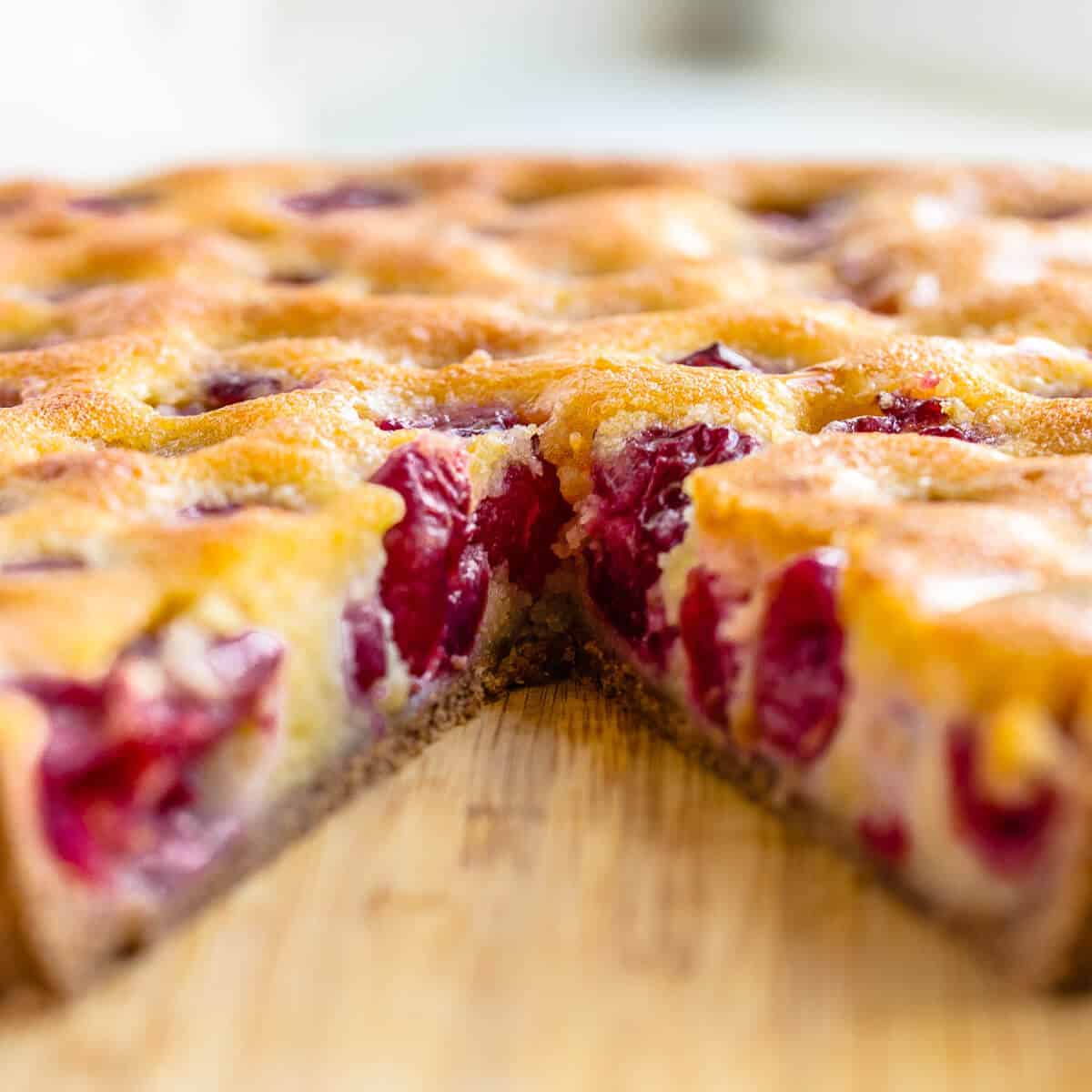 cross section of cherry tart on wooden board.