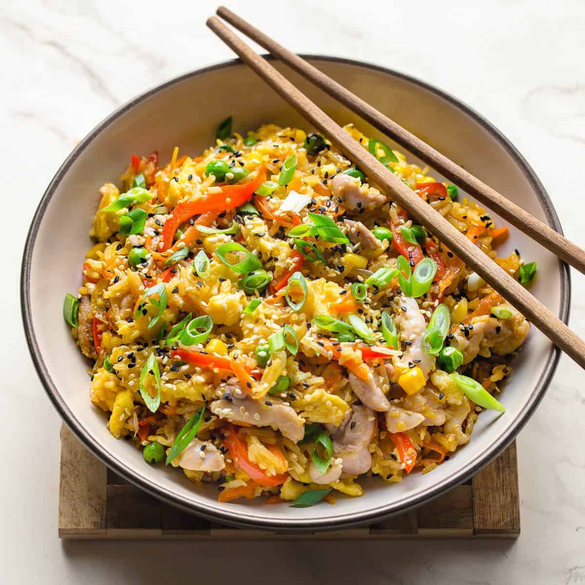 chicken fried rice in a bowl with chopsticks