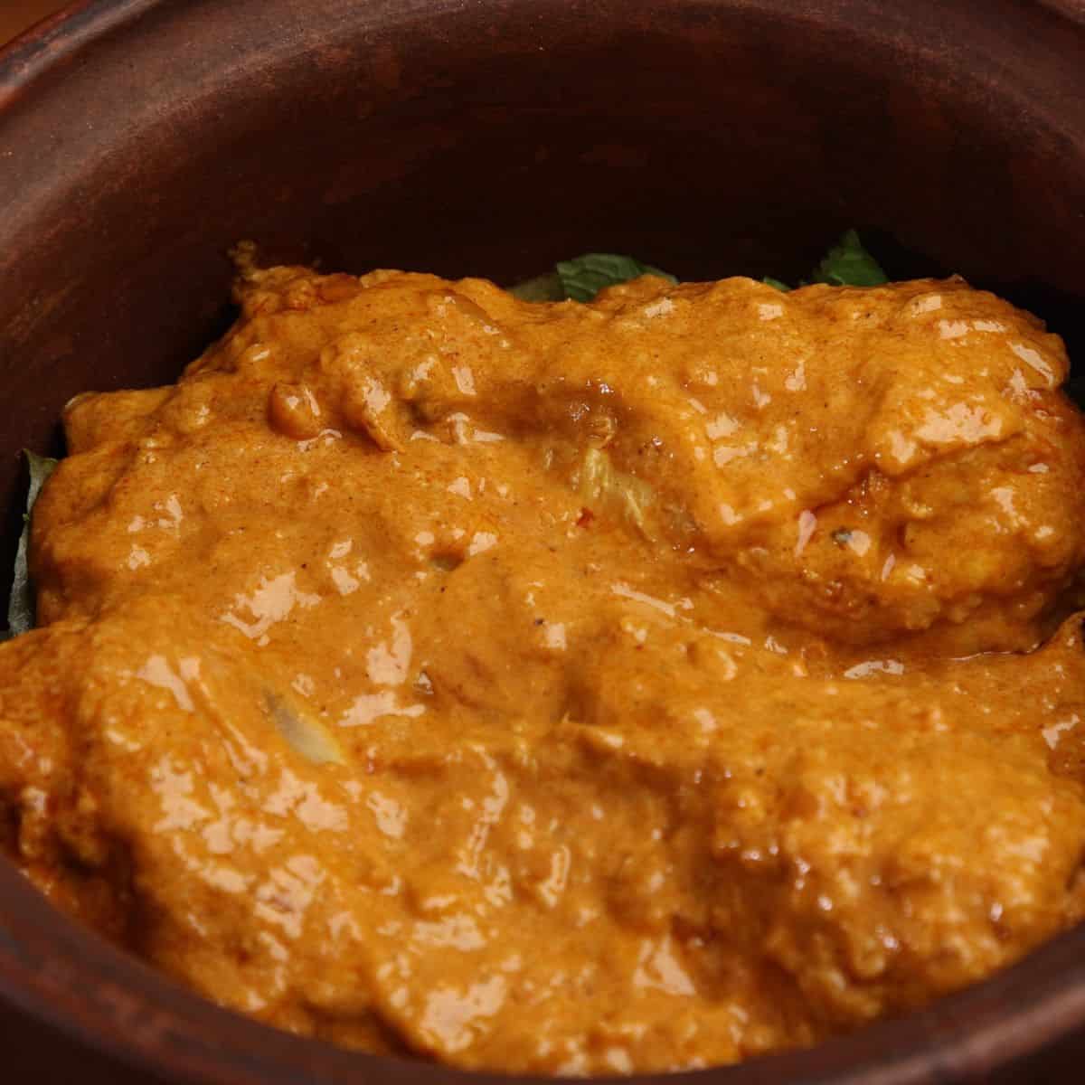 Chicken with gravy in a clay pot.