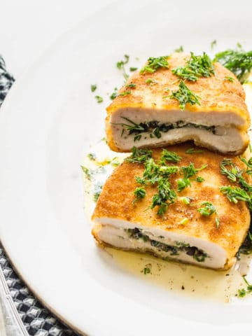 chicken kiev with mashed potatoes and dill on a white plate