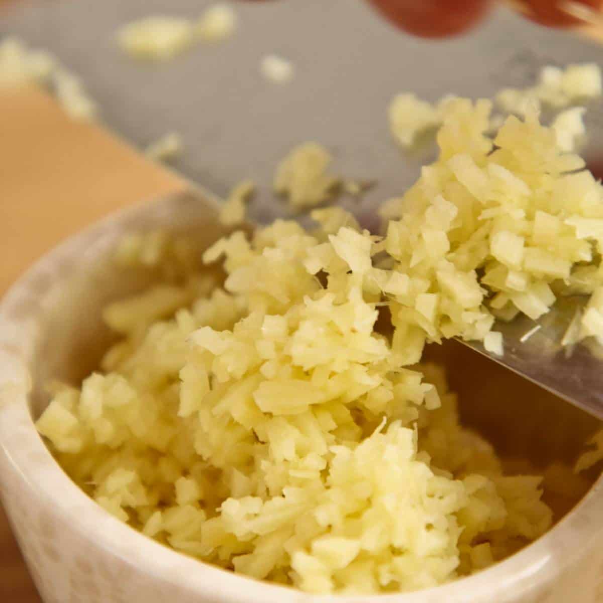 Chopped garlic in white bowl.