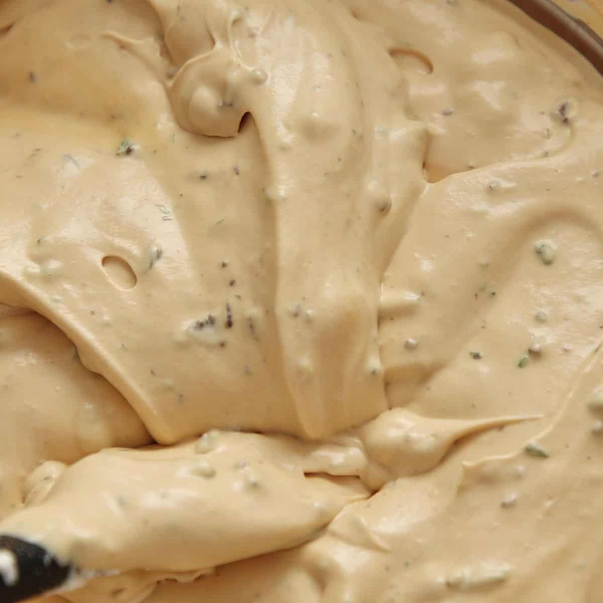 Chopped mint chocolate folded into caramel mousse showing green flecks evenly distributed throughout.
