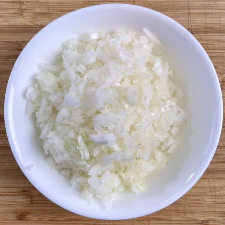 Chopped onions in a white bowl.
