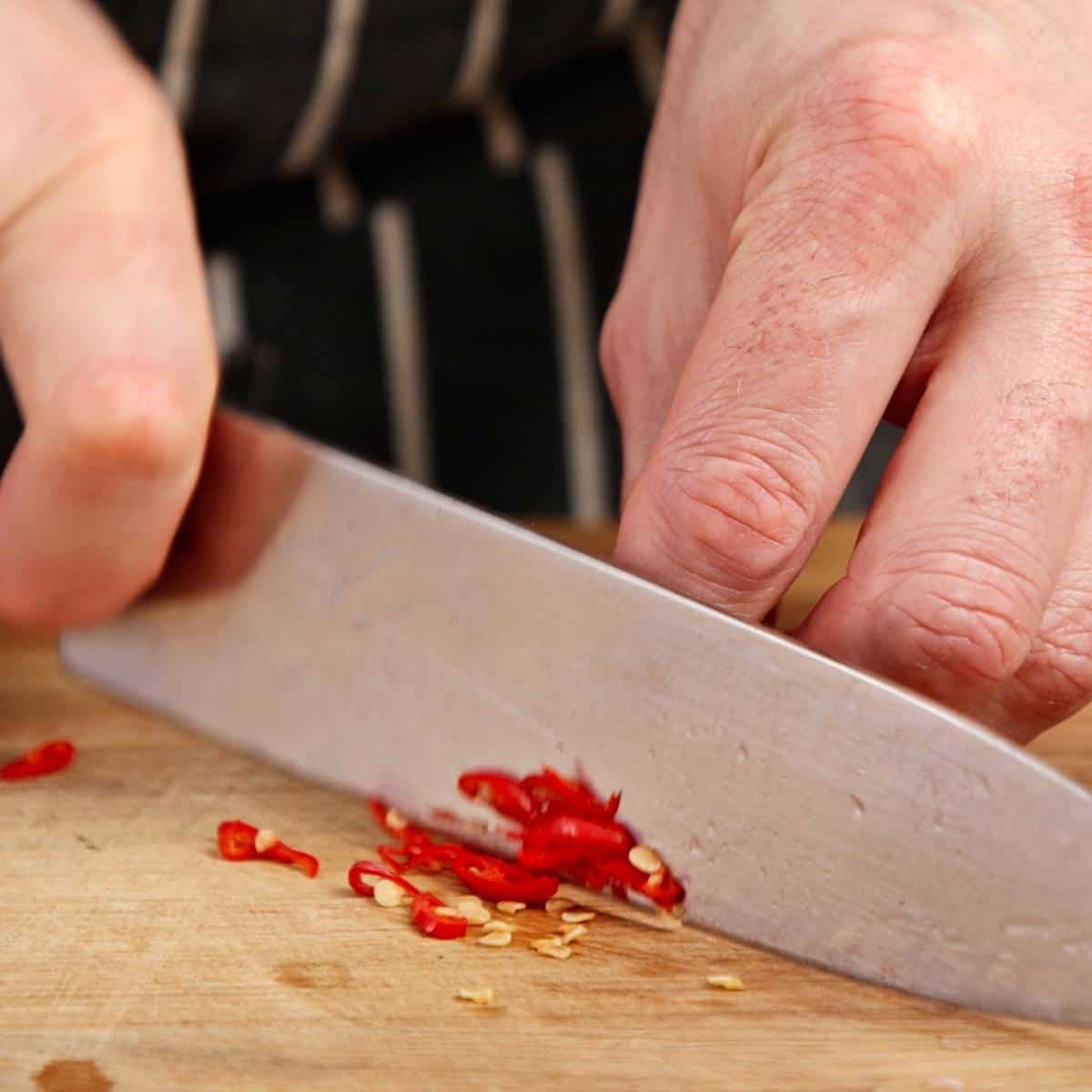 Chopping red chili.