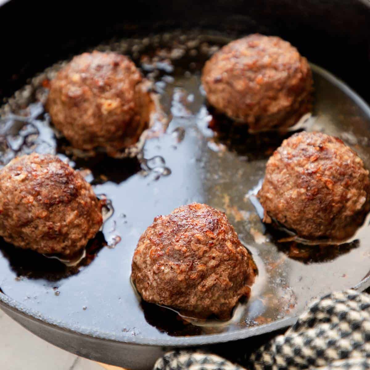 Baked Frikkadels in a skillet.