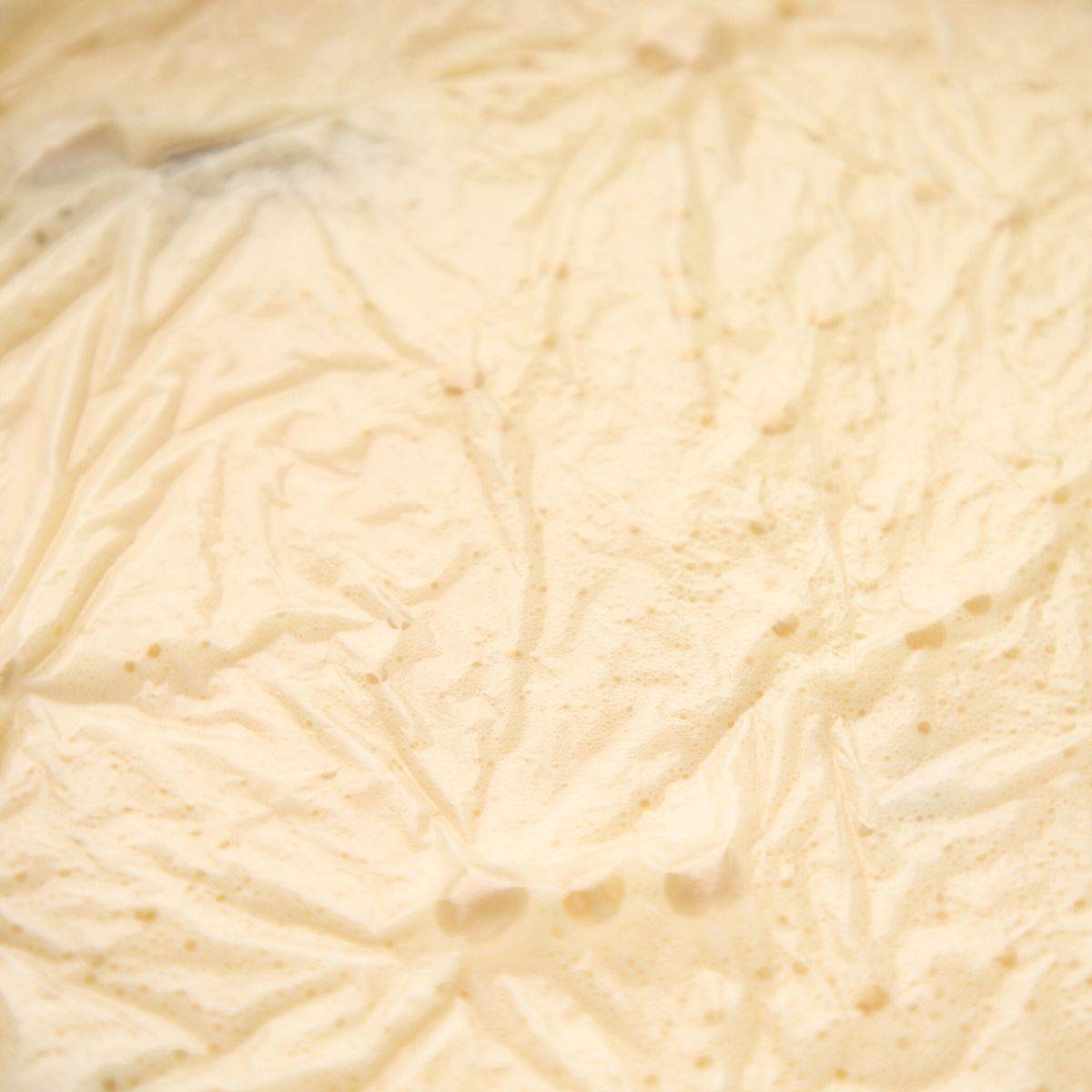Chilled custard in a bowl under plastic wrap.