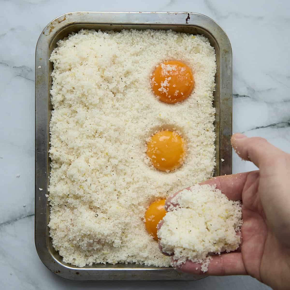 Covering egg yolks with salt cure mixture.