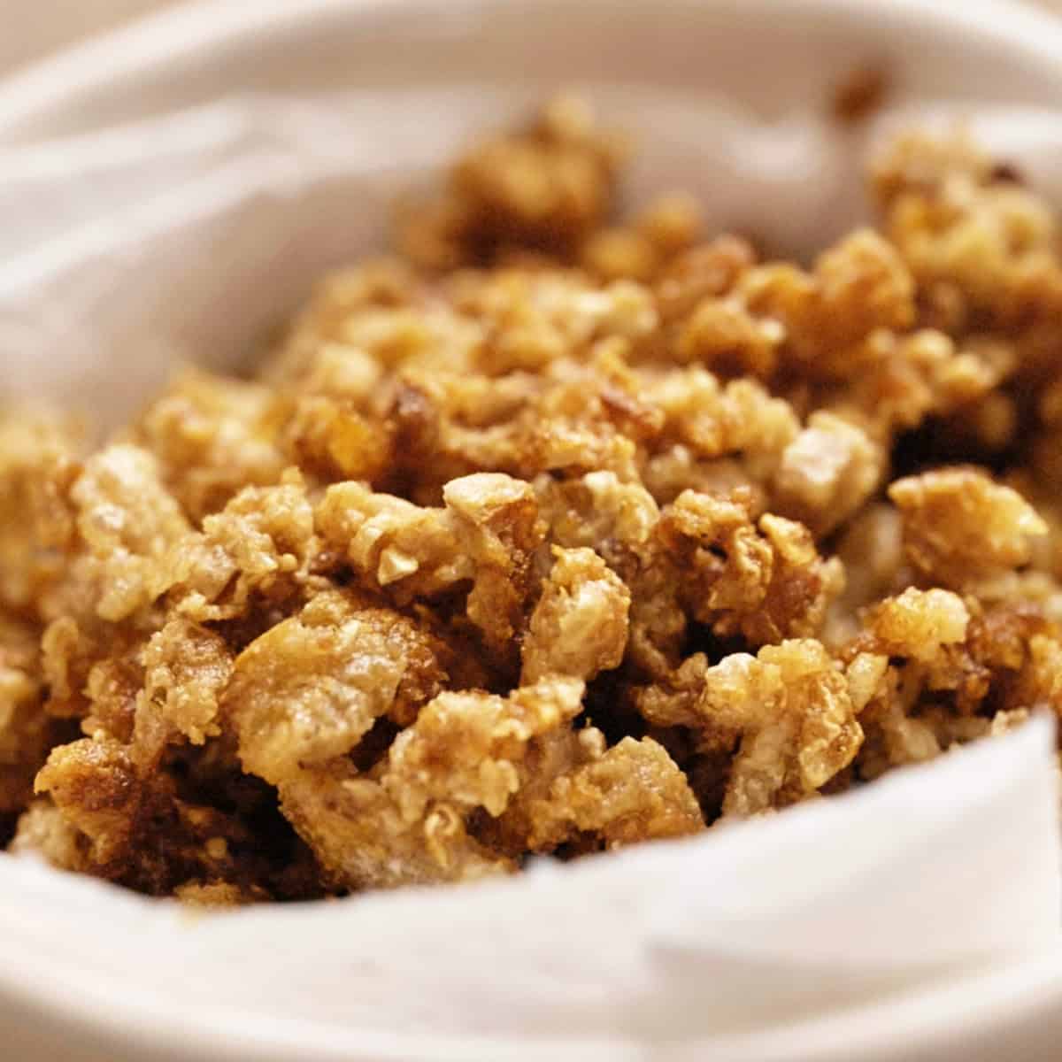 Crispy Chicken skin crackling in a small white bowl.