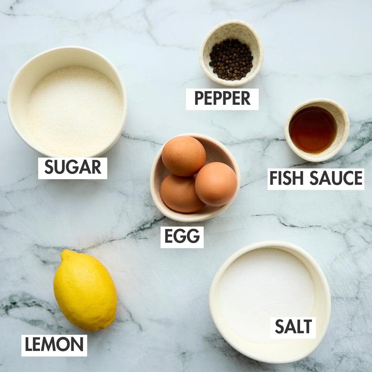 Ingredients for salt cured egg yolks on a marbled surface.