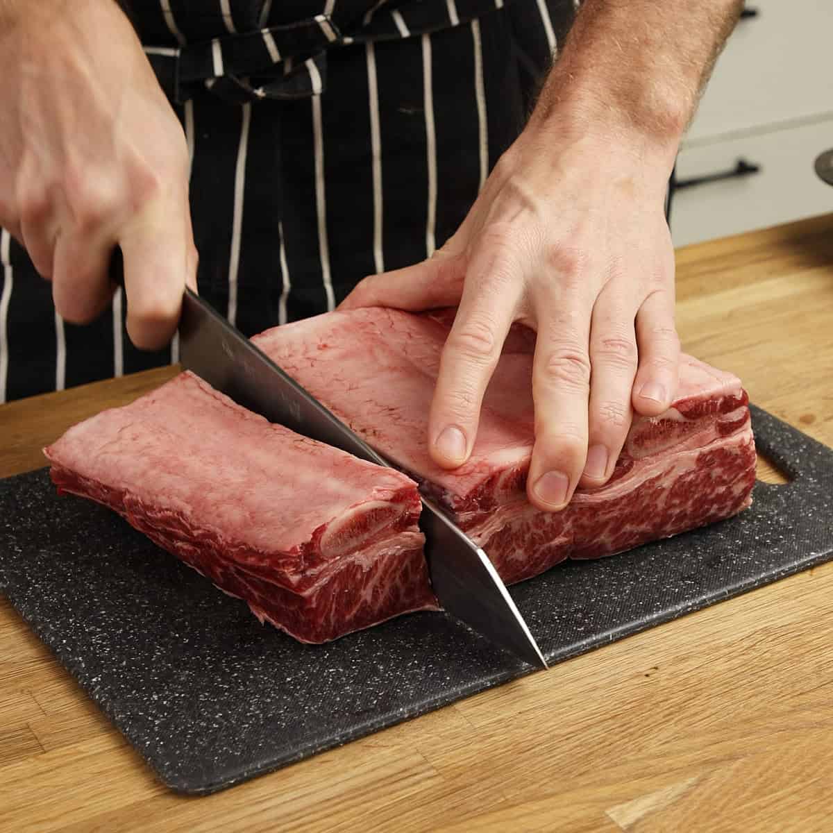 Cutting bone-in short ribs.