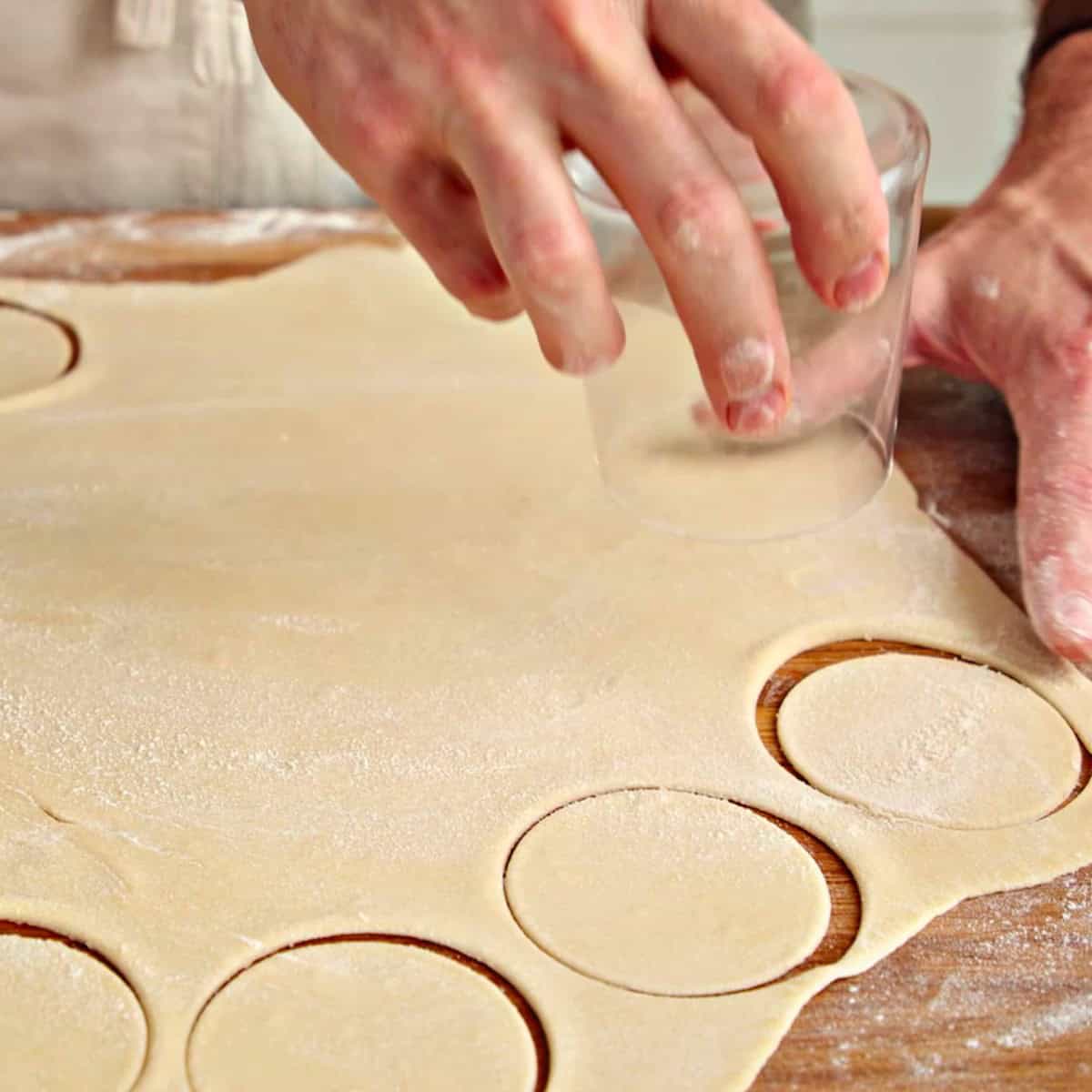 Cutting dough circles with a glass.