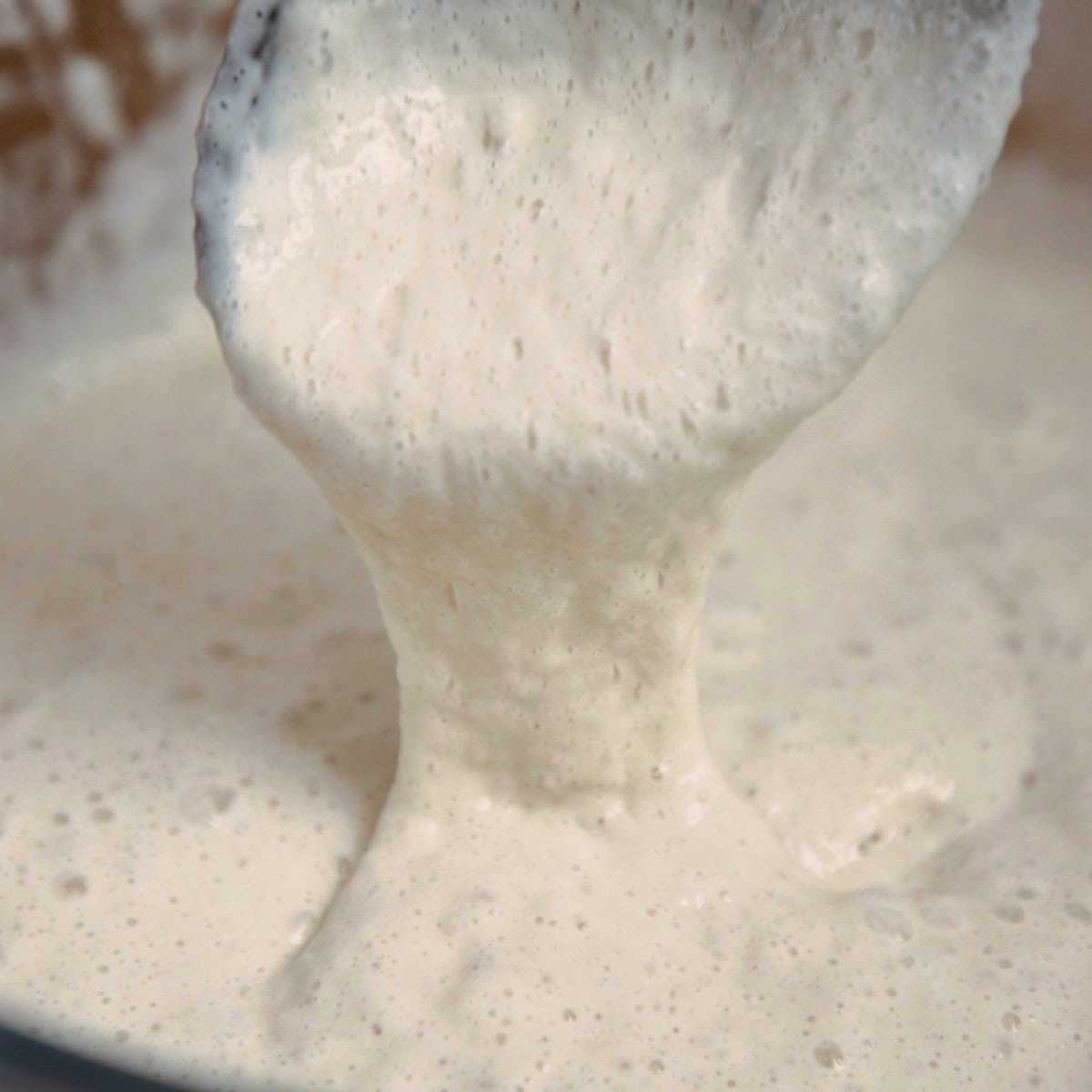 Close up of proven crumpet dough.