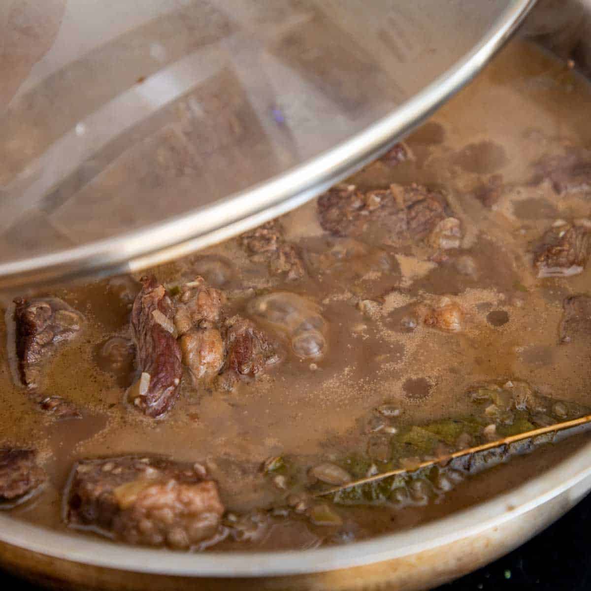 Meat cooking in gravy.