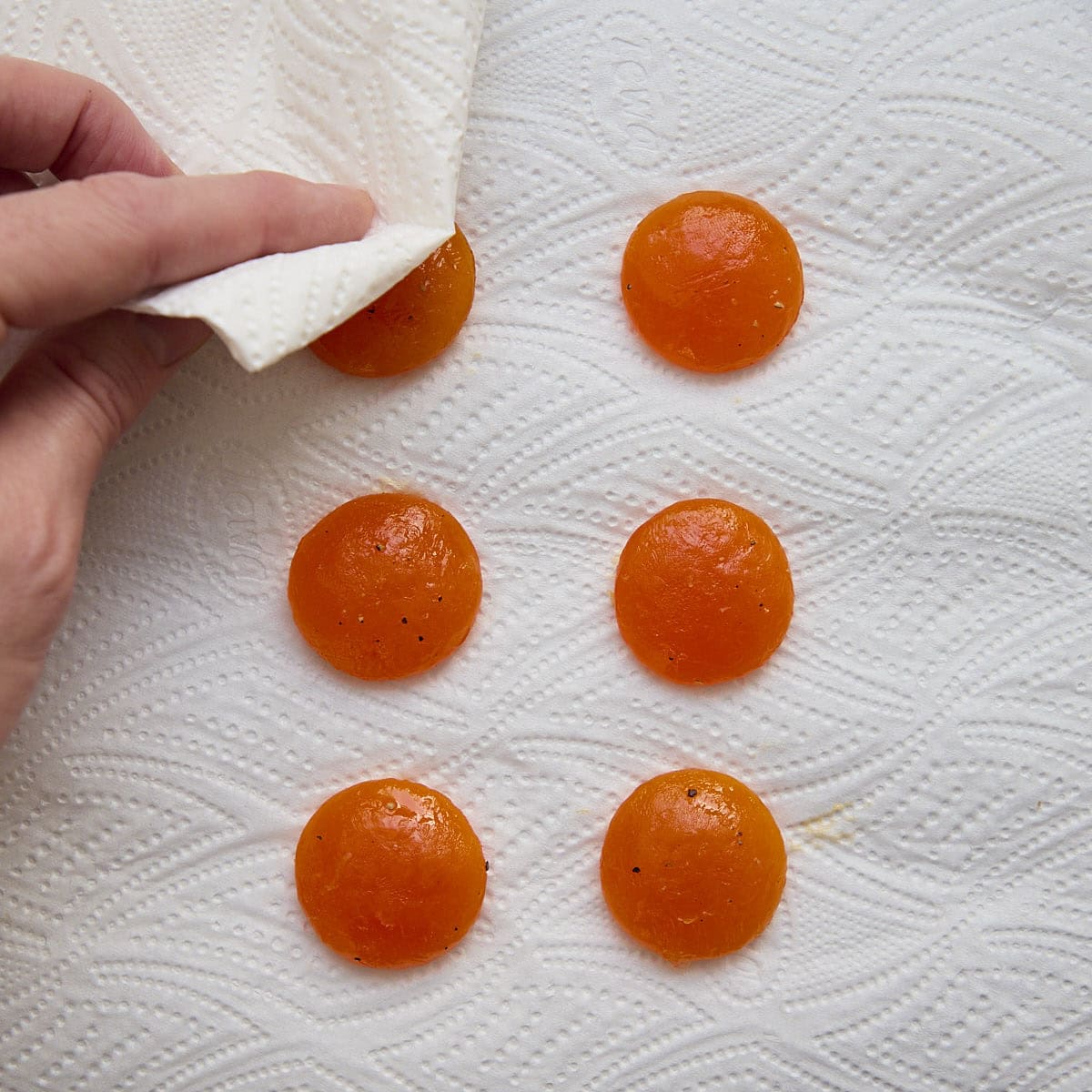 Patting egg yolks dry with a paper towel.