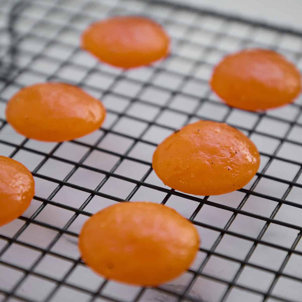 Placing egg yolks onto a wire rack.