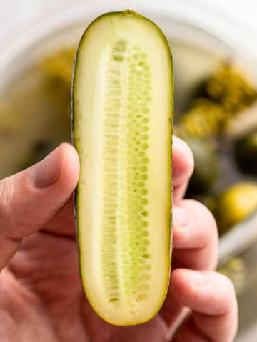 fermented cucumber cut in half.