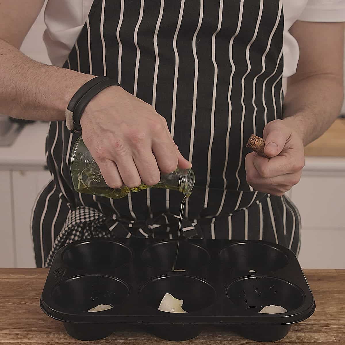 Pouring oil into a black tray.