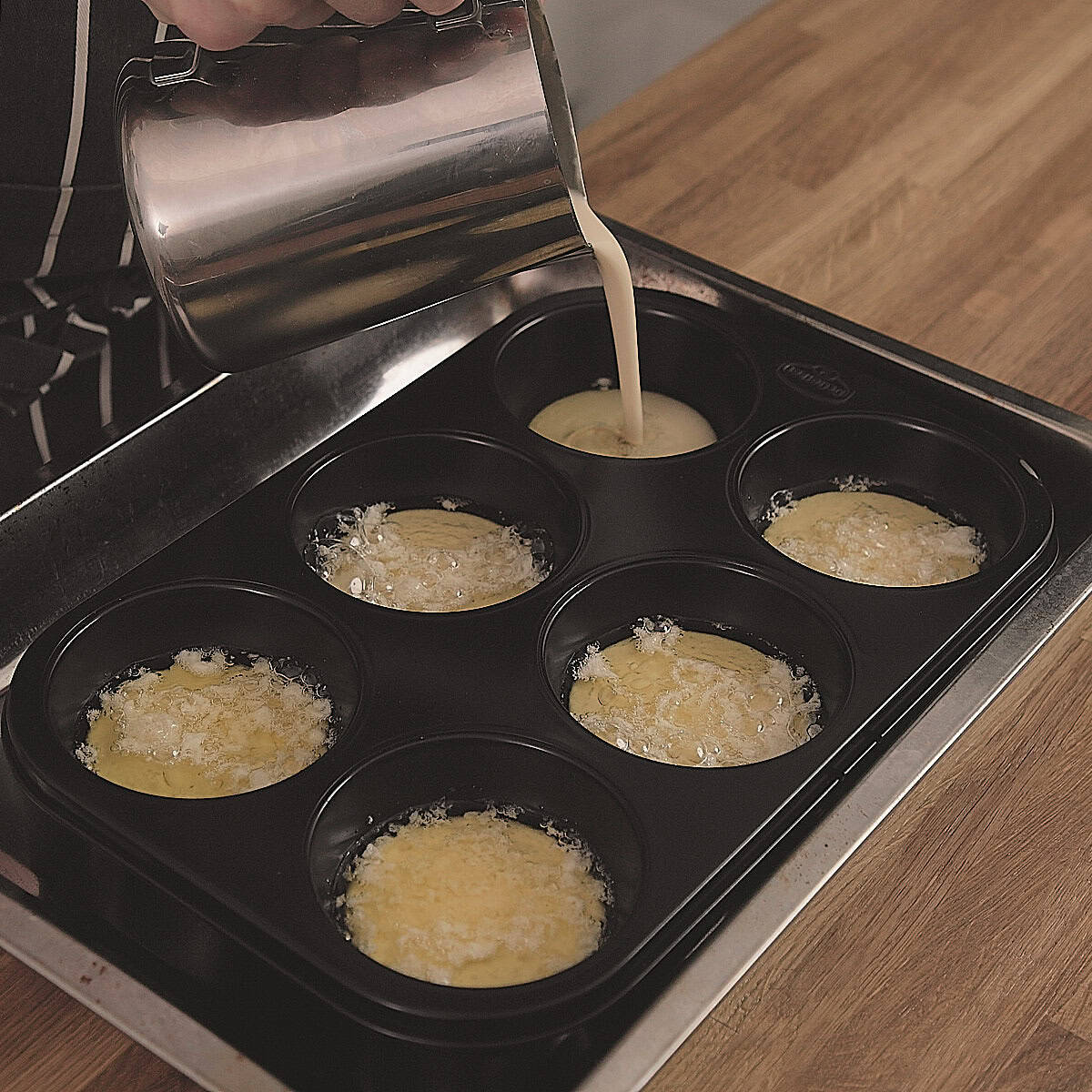 Pouring Yorkshire pudding batter into hot oil.